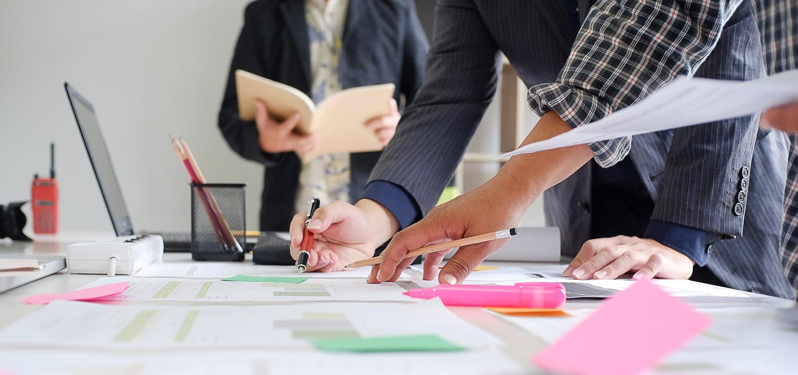 Opdrachtgevers en vakspecialisten bespreken een vertaalproject met documenten en planning
